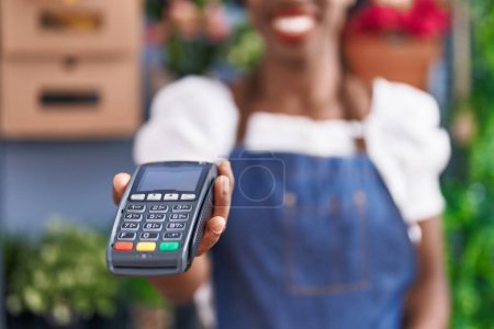 Photo for African american woman florist smiling confident holding data phone at florist store - Royalty Free Image