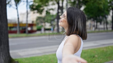 Photo for Young beautiful hispanic woman with open arms at the park in Vienna - Royalty Free Image