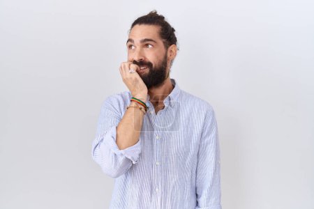 Téléchargez les photos : Homme hispanique avec barbe portant chemise décontractée l'air stressé et nerveux avec les mains sur les ongles mordants de la bouche. problème d'anxiété. - en image libre de droit