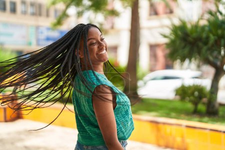 Téléchargez les photos : Afro-américaine femme souriant confiant tourner sur lui-même au parc - en image libre de droit