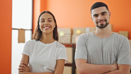 Photo for Two confident workers, man and woman, together smiling with arms crossed at their workplace - Royalty Free Image