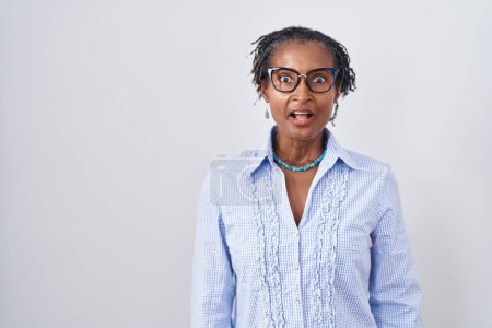 Photo for African woman with dreadlocks standing over white background wearing glasses afraid and shocked with surprise expression, fear and excited face. - Royalty Free Image