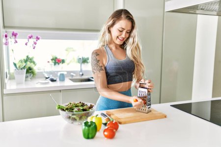 Photo for Young woman smiling confident scratching carrot for salad at kitchen - Royalty Free Image