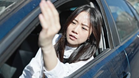 Téléchargez les photos : Jeune femme chinoise stressé voiture de conduite à la rue - en image libre de droit
