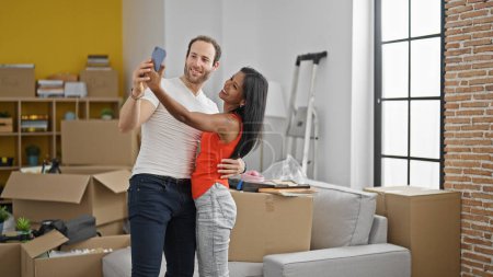 Photo for Beautiful couple make selfie by smartphone smiling at new home - Royalty Free Image