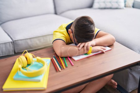 Photo for Adorable hispanic boy unhappy with head on table at home - Royalty Free Image
