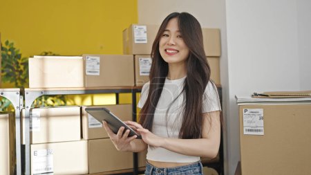 Photo for Young chinese woman ecommerce business worker using touchpad at office - Royalty Free Image