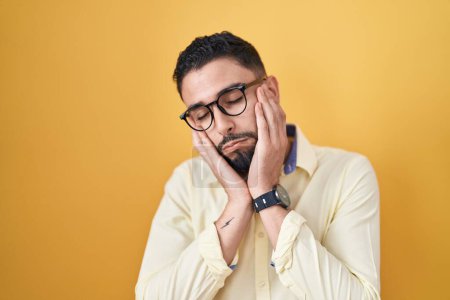 Photo for Hispanic young man wearing business clothes and glasses tired hands covering face, depression and sadness, upset and irritated for problem - Royalty Free Image