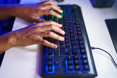 Téléchargez les photos : Femme afro-américaine utilisant un clavier d'ordinateur à la salle de jeux - en image libre de droit