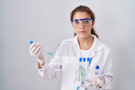 Photo for Young caucasian scientist woman working with laboratory samples relaxed with serious expression on face. simple and natural looking at the camera. - Royalty Free Image