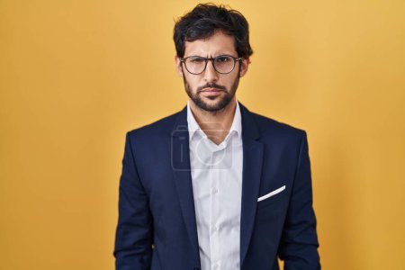 Photo for Handsome latin man standing over yellow background skeptic and nervous, frowning upset because of problem. negative person. - Royalty Free Image