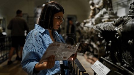 Téléchargez les photos : Jeune belle femme hispanique visitant crypte brochure de lecture à la crypte impériale à Vienne - en image libre de droit