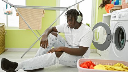 Photo for African american man listening to music at laundry room - Royalty Free Image