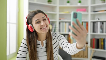 Téléchargez les photos : Young beautiful hispanic woman student smiling confident having video call at library university - en image libre de droit