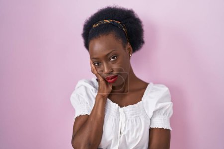 Photo for African woman with curly hair standing over pink background thinking looking tired and bored with depression problems with crossed arms. - Royalty Free Image
