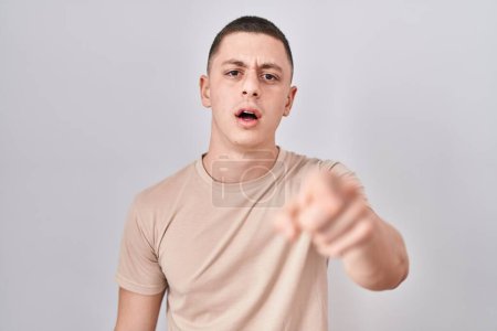 Photo for Young man standing over isolated background pointing displeased and frustrated to the camera, angry and furious with you - Royalty Free Image