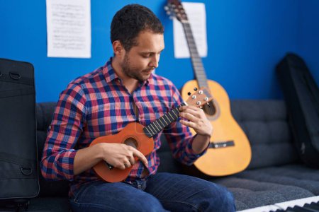 Foto de Joven músico tocando ukelele en el estudio de música - Imagen libre de derechos