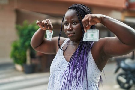 Téléchargez les photos : Femme afro-américaine cassant billet de 100 dollars à la terrasse du café - en image libre de droit