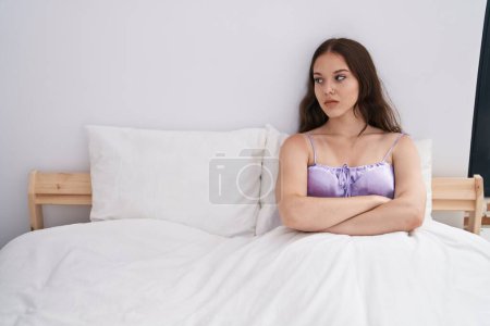 Foto de Mujer joven estresada sentada en la cama en el dormitorio - Imagen libre de derechos