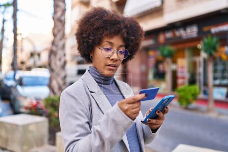 Téléchargez les photos : African american woman executive using smartphone and credit card at street - en image libre de droit