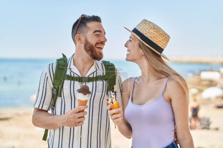 Photo for Man and woman tourist couple smiling confident eating ice cream at seaside - Royalty Free Image