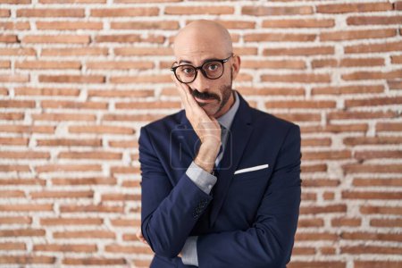 Photo for Bald man with beard wearing business clothes and glasses thinking looking tired and bored with depression problems with crossed arms. - Royalty Free Image