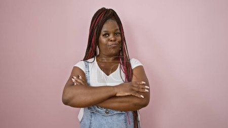 Photo for Swag, serious expression, and lifestyle of a cool african american woman standing relaxed, with arms crossed, looking concentrated over pink isolated background, radiating beautiful casual vibes - Royalty Free Image