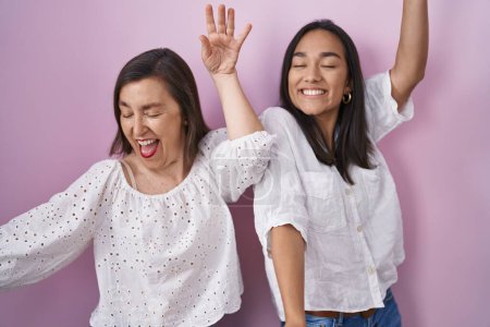 Téléchargez les photos : Mère hispanique et fille ensemble dansant heureux et joyeux, souriant émouvant occasionnel et confiant écoutant de la musique - en image libre de droit