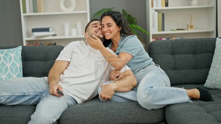 Foto de Hombre y mujer pareja abrazándose viendo la televisión en casa - Imagen libre de derechos