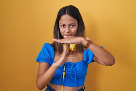 Téléchargez les photos : Jeune femme hispanique debout sur fond jaune faisant un geste avec les mains, frustré et sérieux visage - en image libre de droit