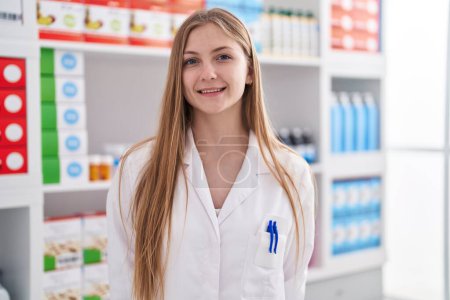 Foto de Young caucasian woman pharmacist smiling confident standing at pharmacy - Imagen libre de derechos
