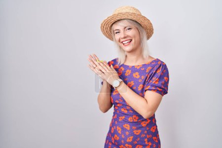 Photo for Young caucasian woman wearing flowers dress and summer hat clapping and applauding happy and joyful, smiling proud hands together - Royalty Free Image