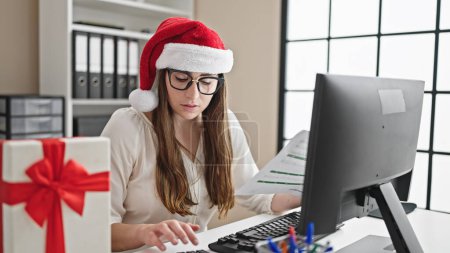 Téléchargez les photos : Jeune belle hispanique femme ouvrière d'affaires célébrant Noël travailler au bureau - en image libre de droit