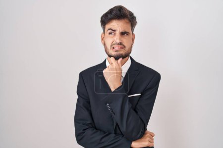Photo for Young hispanic man with tattoos wearing business suit and tie thinking worried about a question, concerned and nervous with hand on chin - Royalty Free Image