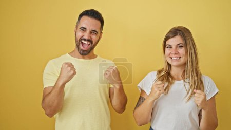 Photo for Man and woman couple smiling confident celebrating over isolated yellow background - Royalty Free Image