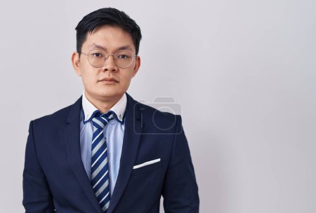 Téléchargez les photos : Jeune homme asiatique en costume d'affaires et cravate détendue avec une expression sérieuse sur le visage. simple et naturel regardant la caméra. - en image libre de droit