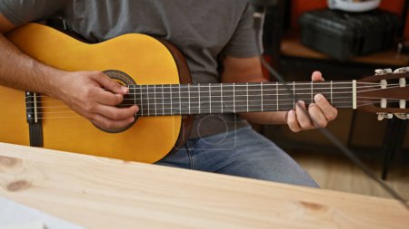 Photo for Young latin man musician playing classical guitar at music studio - Royalty Free Image
