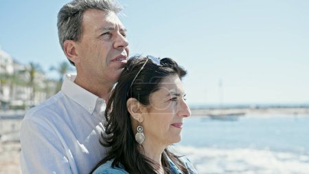 Téléchargez les photos : Senior couple homme et femme debout ensemble avec une expression détendue au bord de la mer - en image libre de droit