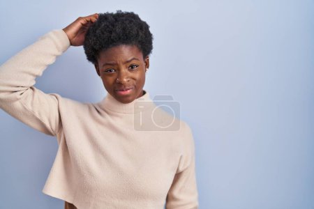 Téléchargez les photos : Femme afro-américaine debout sur fond bleu confondre et s'interroger sur la question. incertain avec doute, pensant la main sur la tête. concept coûteux. - en image libre de droit