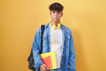 Photo for Hispanic teenager wearing student backpack and holding books depressed and worry for distress, crying angry and afraid. sad expression. - Royalty Free Image