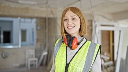 Photo for Young blonde woman architect smiling confident standing at construction site - Royalty Free Image