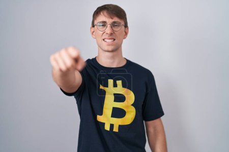 Photo for Caucasian blond man wearing bitcoin t shirt pointing displeased and frustrated to the camera, angry and furious with you - Royalty Free Image