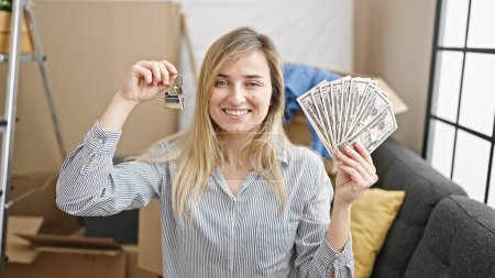 Téléchargez les photos : Jeune femme blonde tenant des dollars et la clé à la nouvelle maison - en image libre de droit