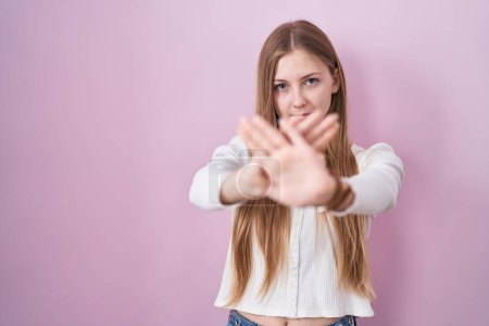 Téléchargez les photos : Jeune femme caucasienne debout sur fond rose expression de rejet croisement des bras et des paumes faisant signe négatif, visage en colère - en image libre de droit