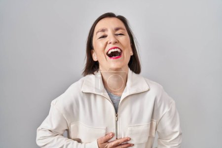 Foto de Middle age hispanic woman standing over isolated background smiling and laughing hard out loud because funny crazy joke with hands on body. - Imagen libre de derechos