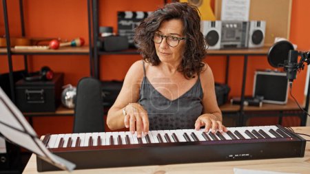 Téléchargez les photos : Musicienne hispanique du Moyen Âge jouant du piano au studio de musique - en image libre de droit