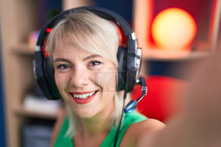 Photo for Young blonde woman streamer smiling confident make selfie by camera at gaming room - Royalty Free Image