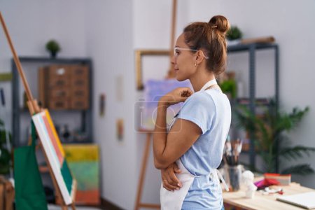 Photo for Brunette woman painting at art studio looking to side, relax profile pose with natural face with confident smile. - Royalty Free Image