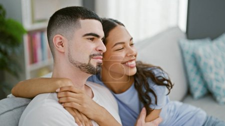 Photo for Beautiful couple's joyous moment, casually hugging, smiling, and enjoying life together on sofa at home - Royalty Free Image