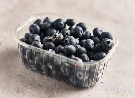 Photo for Delicious group of blueberries on plastic box marble surface - Royalty Free Image